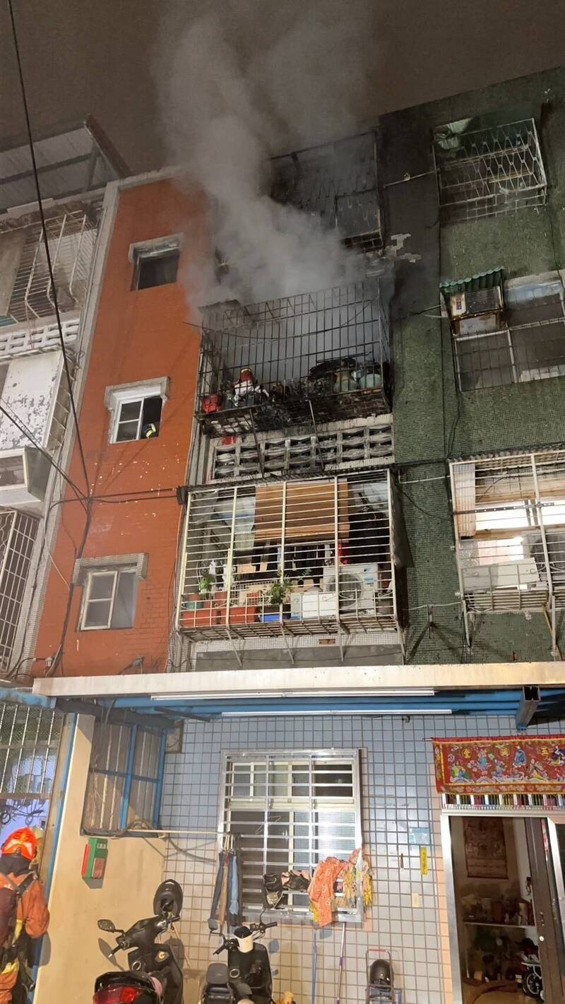 新北市板桥一处民宅今天凌晨失火,近八旬女住户疑听到住警器警报,及时逃出,消防搜救小组随后架梯救出受困火场男子,奇迹仅受轻伤,起火原因仍待调查厘清。(记者吴仁捷翻摄) 新北市板桥一处民宅今天凌晨失火,近八旬女住户疑听到住警器警报,及时逃出,消防搜救小组随后架梯救出受困火场男子,奇迹仅受轻伤,起火原因仍待调查厘清。(记者吴仁捷翻摄)