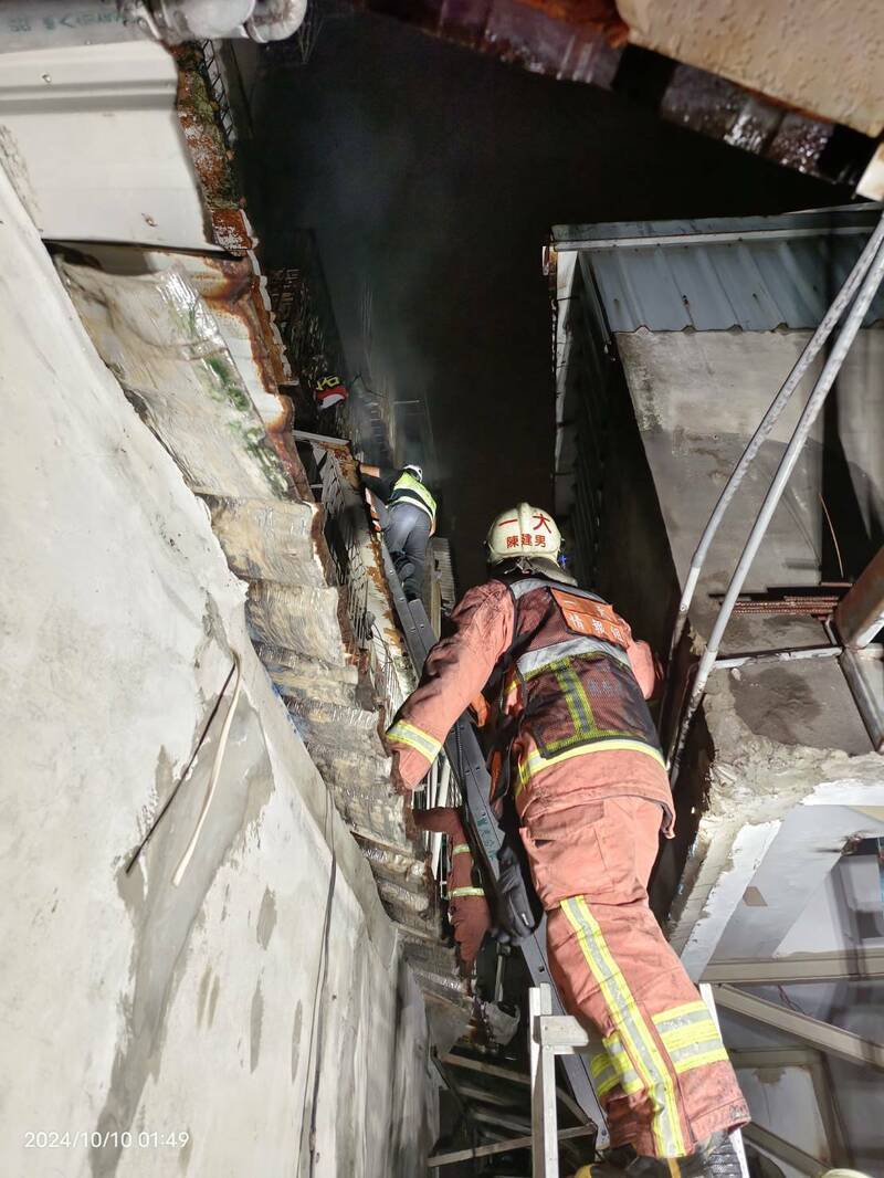 新北市板桥一处民宅今天凌晨失火,近八旬女住户疑听到住警器警报,及时逃出,消防搜救小组随后架梯救出受困火场男子,奇迹仅受轻伤,起火原因仍待调查厘清。(记者吴仁捷翻摄) 新北市板桥一处民宅今天凌晨失火,近八旬女住户疑听到住警器警报,及时逃出,消防搜救小组随后架梯救出受困火场男子,奇迹仅受轻伤,起火原因仍待调查厘清。(记者吴仁捷翻摄)