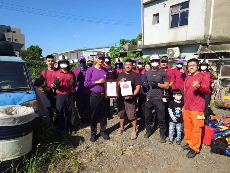 民间业者谢祥治先生(前排手握提袋)提供场地与报废车辆,协助消防训练。 (复旦分队提供) 民间业者谢祥治先生(前排手握提袋)提供场地与报废车辆,协助消防训练。 (复旦分队提供)