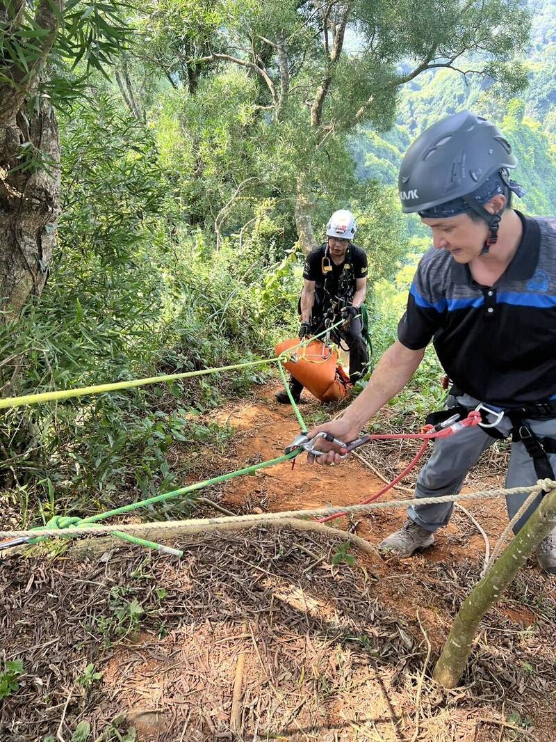 彰化夫妻档爬山,惟妻子不慎坠落50公尺边坡伤重身亡,搜救人员在接近垂直的陡坡架绳将人拉上步道。(记者刘滨铨翻摄) 彰化夫妻档爬山,惟妻子不慎坠落50公尺边坡伤重身亡,搜救人员在接近垂直的陡坡架绳将人拉上步道。(记者刘滨铨翻摄)