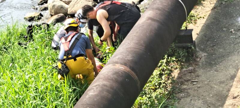 高雄唐女落水险被冲走,警消涉水救人,协助送医保命。(读者提供) 高雄唐女落水险被冲走,警消涉水救人,协助送医保命。(读者提供)
