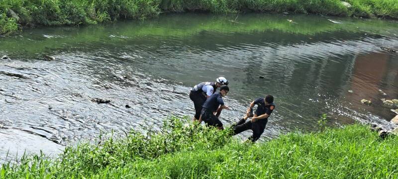 高雄唐女落水险被冲走,警消涉水救人,协助送医保命。(读者提供) 高雄唐女落水险被冲走,警消涉水救人,协助送医保命。(读者提供)