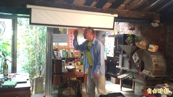 「石店子69有机书店」主人卢文钧拉下布幕,想透过电影让老屋、实体书店散发新的魅力。(记者黄美珠摄) 「石店子69有机书店」主人卢文钧拉下布幕,想透过电影让老屋、实体书店散发新的魅力。(记者黄美珠摄)