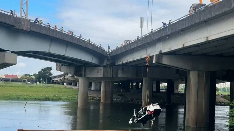 轿车经吊挂打捞上岸。(记者徐圣伦翻摄) 轿车经吊挂打捞上岸。(记者徐圣伦翻摄)
