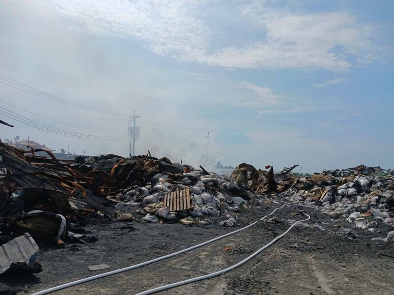 高市永安区保安路一间地下塑胶工厂前天发生火警,业者今天以重机具整理现场,结果发生复燃。(民众提供)(记者苏福男摄) 高市永安区保安路一间地下塑胶工厂前天发生火警,业者今天以重机具整理现场,结果发生复燃。(民众提供)(记者苏福男摄)