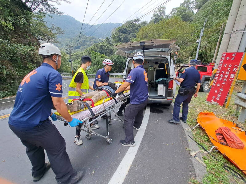 坠溪床的受伤骑士拖拉至路面后,由救护车送医院救治。(南投县消防局提供) 坠溪床的受伤骑士拖拉至路面后,由救护车送医院救治。(南投县消防局提供)