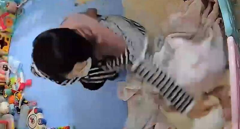 陈女压男婴头部。(读者提供) 陈女压男婴头部。(读者提供)