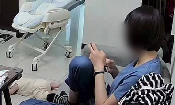 男婴趴地流血痛哭,陈女仍在滑手机。(读者提供) 男婴趴地流血痛哭,陈女仍在滑手机。(读者提供)